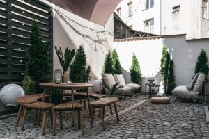 a patio with a table and chairs and trees at House of LoftAffair in Krakow