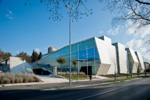 un grande edificio in vetro con una persona che cammina davanti di Apartman Andi a Fiume (Rijeka)