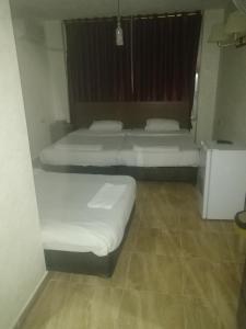 Cette chambre comprend 3 lits et une fenêtre. dans l'établissement Al-Houriat Hotel, à Amman