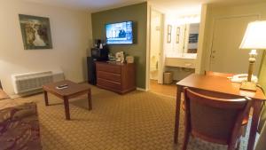 a living room with a desk and a tv at Fort Davidson Hotel in Pilot Knob