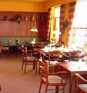 une salle à manger avec des tables et des chaises en bois dans l'établissement Domhotel Bed & Breakfast, à Schleswig
