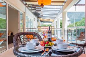 a table with a bowl of fruit and a bottle of wine at Number 8 Olivia Apartments in Oludeniz