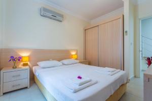 a bedroom with a white bed with towels on it at Number 8 Olivia Apartments in Oludeniz +19 photos