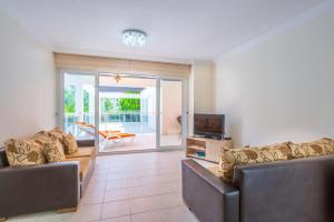 a living room with two couches and a television at Number 8 Olivia Apartments in Oludeniz