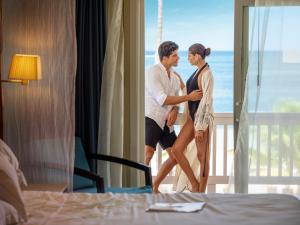 a man and a woman standing on a bed at Barceló Bávaro Beach - Adults Only All Inclusive in Punta Cana