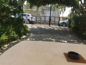 un chapeau noir assis sur un trottoir à côté d'une clôture dans l'établissement Anita Guest House, à Tivat