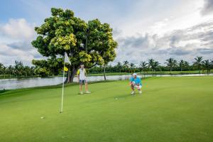 2 persone che giocano a golf su un campo di Barceló Bávaro Beach - Adults Only All Inclusive a Punta Cana