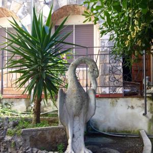 a statue of two birds standing next to a plant at Villa Merina in Vieste
