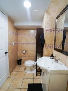 y baño con lavabo blanco y aseo. en Trendy 1BR Basement with Laundry & Covered Parking - Central Trendy, en Dunning