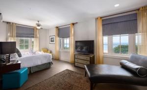 a bedroom with a bed and a tv and a couch at White House Hotel in Biloxi