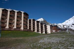 a building with a snow covered mountain in the background at Val Thorens Temple of the Sun - ski in, ski out in Val Thorens