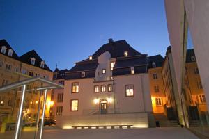 ein großes Gebäude mit Lichtern davor in der Unterkunft Hotel Parc Beaux Arts in Luxemburg (Stadt)
