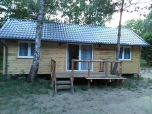een klein huis met een veranda ervoor bij Ośrodek Rodzinny in Gwieździn