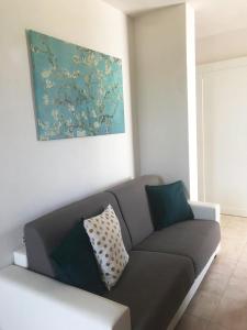 un soggiorno con divano grigio e un dipinto di Vere Vacanze a Torre dell'Orso