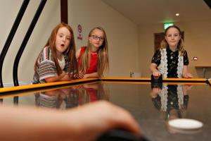 three young girls are standing in front of a table at Causeway Coast Wigwams in Bushmills