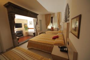 a hotel room with two beds and a fireplace at Hotel Fioroni in Bellagio