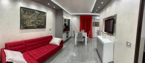 a living room with a red couch and a tv at Deluxe Home appartamento in Sciacca