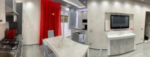 a kitchen with a tv and a red curtain at Deluxe Home appartamento in Sciacca