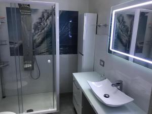 a bathroom with a sink and a glass shower at Deluxe Home appartamento in Sciacca +22 photos