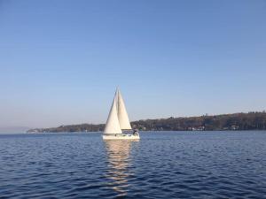 una barca a vela bianca sull'acqua di un lago di Holiday House Camillina a Salò