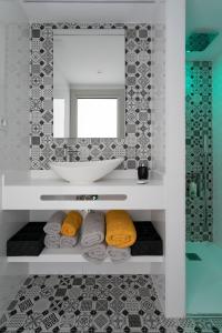 ein Badezimmer mit einem Waschbecken, einem Spiegel und Handtüchern in der Unterkunft Apartamento Deluxe a 50m de Playa - Aire Wifi Parking in Gandía