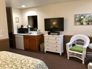 um quarto de hotel com um quarto com uma televisão e uma cama em Bay Breeze Resort em Ephraim