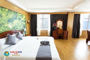 a hotel room with a large bed and a desk at Hoang Yen Hotel in Quy Nhon