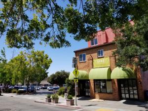 un edificio in mattoni con un negozio con tende verdi di SenS Hotel & Vanne Bistro Berkeley a Berkeley