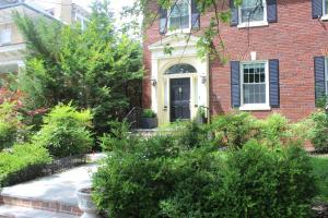 a brick house with a black door and some bushes at COMFY 3 Bdrm Basement Home in Washington, D.C.