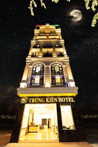 a tall building with a sign on it at night at TRUNG KIÊN HOTEL in Hai Phong