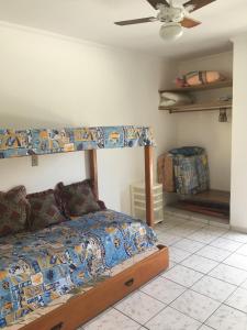 Schlafzimmer mit einem Bett und einem Deckenventilator in der Unterkunft Acomodação no paraíso in Ubatuba