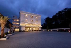 a large white building with a parking lot at night at HOTEL PARK RESIDENCY in Trichūr
