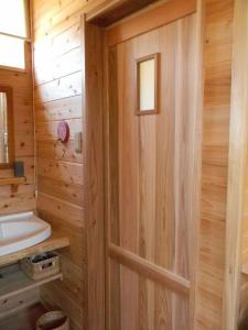 baño de madera con aseo y puerta en TIDA Resort Yakushima 旧 屋久島海の胡汀路てぃーだ, en Yakushima 136 fotos más