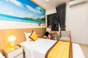 a hotel room with a woman sitting in a window at TRUNG KIÊN HOTEL in Hai Phong