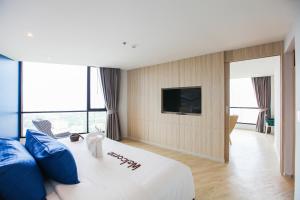 a hotel room with a large bed and a large window at Brighton Grand Hotel Pattaya - SHA Extra Plus in Pattaya North