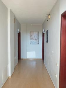 an empty hallway with white walls and wooden floors at Hotel Afrodite in Dhërmi