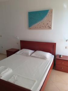 a bedroom with a bed and a painting on the wall at Hotel Afrodite in Dhërmi