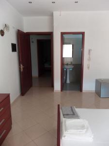 a room with a bed and a bathroom with a sink at Hotel Afrodite in Dhërmi