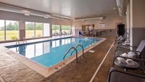 ein Pool in einem Hotelzimmer mit Stühlen drum herum in der Unterkunft Best Western Plus Parkside Inn & Suites in Olney