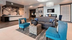 Best Western Plus Parkside Inn & Suites في Olney: غرفة معيشة مع أريكة وكرسيين
