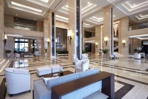 Wyndham Opi Hotel Palembang في باليمبانغ: لوبي فيه كنب وكراسي في مبنى