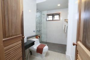 a bathroom with a toilet and a glass shower at Lanta Casa Blanca in Ko Lanta