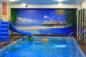 a swimming pool with a slide and a mural at Aqualife Spa hotel on Leninskogo Komsomola in Cheboksary