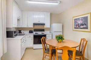 a kitchen with white cabinets and a table with chairs at Comfort Inn Douglasville - Atlanta West in Douglasville