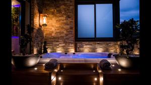 a bathroom with a tub with two potted plants and a window at B&B Villa sensorielle in Nice