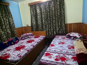 two twin beds in a room with curtains at Vamoose Newahang in Pedong