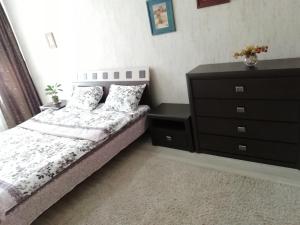 a bedroom with a bed and a dresser at Apartment Lenina in Vitebsk