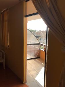 Habitación con puerta de cristal y balcón. en Hotel Sol de Huanchaco, en Huanchaco