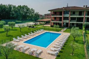 uma vista sobre uma piscina com espreguiçadeiras e um hotel em Appartamenti Residence Parco em Sirmione