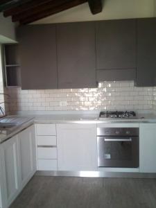 a kitchen with white cabinets and a stove top oven at Casa Renacci in Subbiano